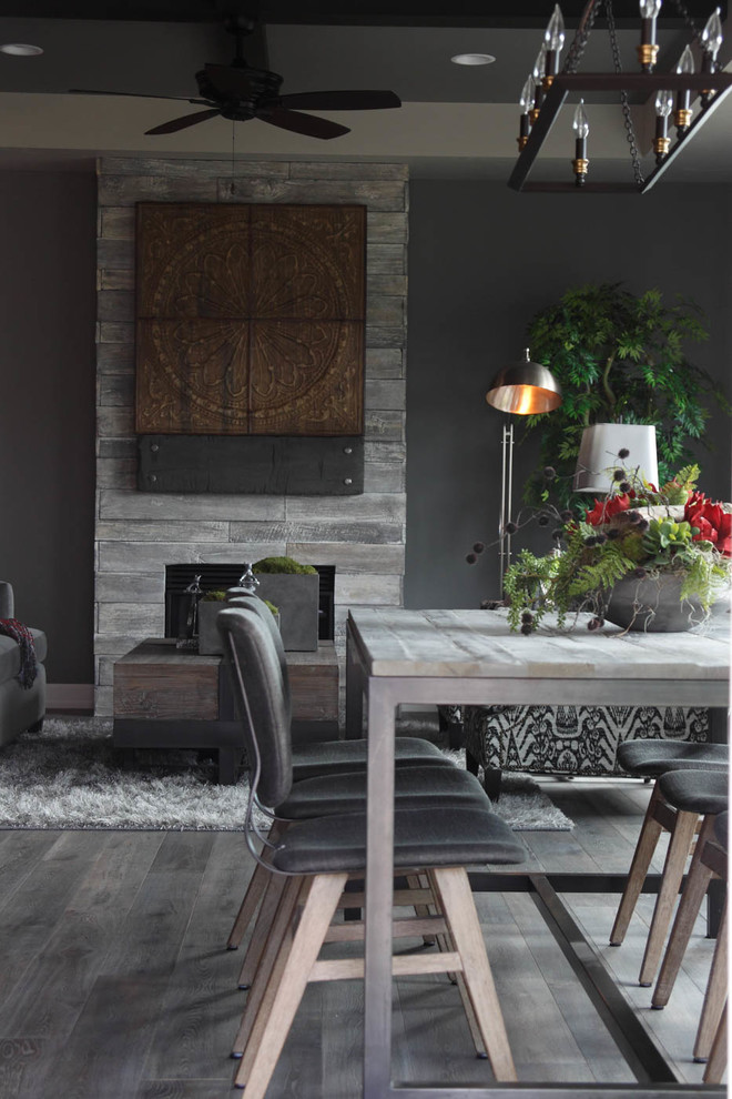 На фото: гостиная-столовая среднего размера в стиле неоклассика (современная классика) с серыми стенами, паркетным полом среднего тона, стандартным камином и фасадом камина из дерева с