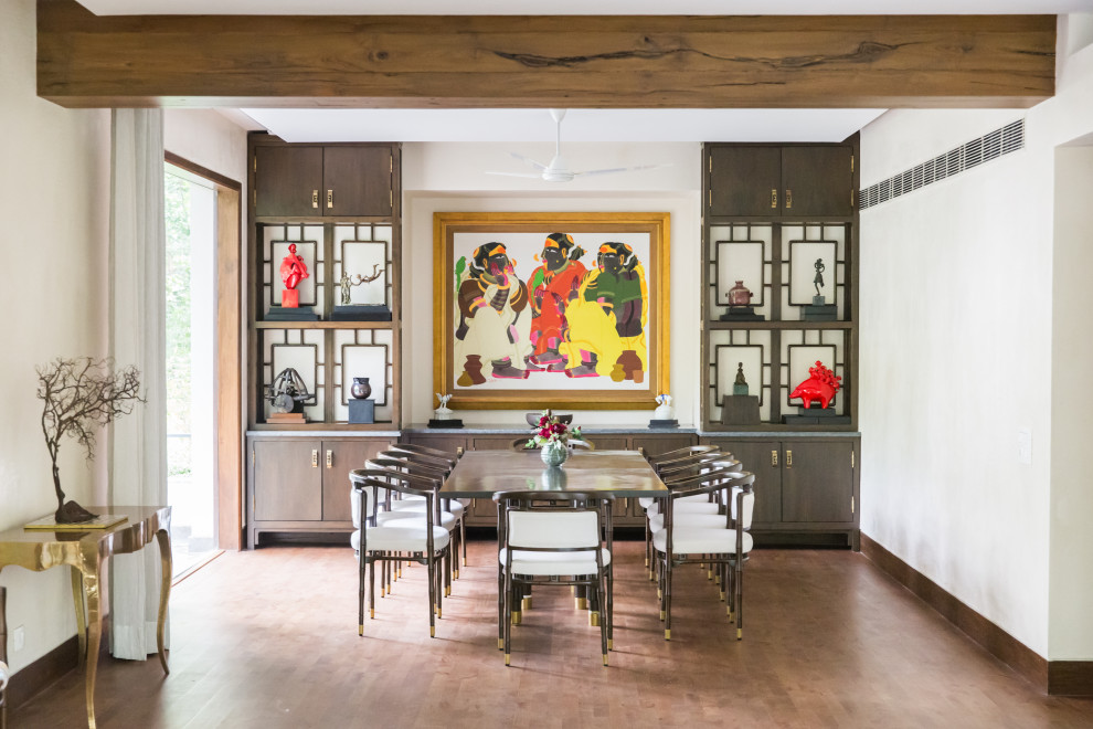 Photo of a world-inspired dining room in Delhi with white walls, dark hardwood flooring and brown floors.