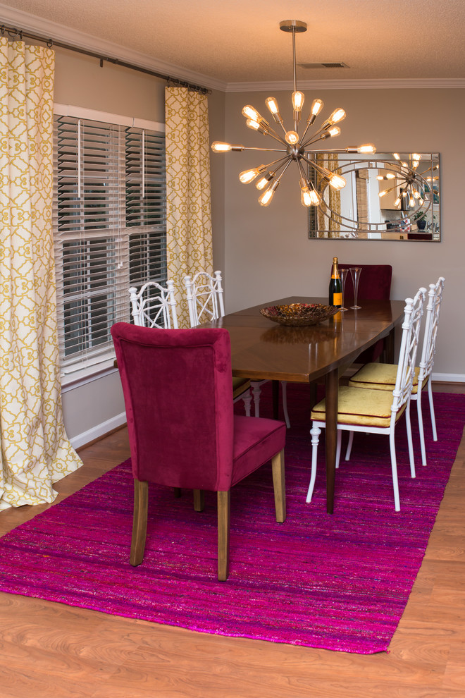 Cette photo montre une petite salle à manger ouverte sur le salon chic avec un mur gris et un sol en bois brun.