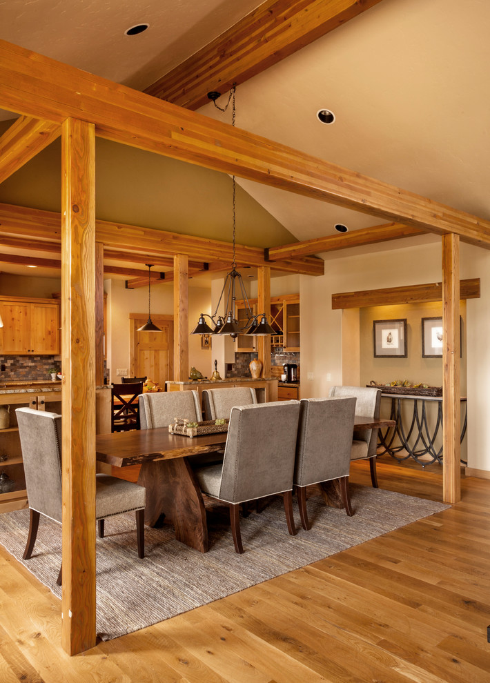 Cette photo montre une salle à manger ouverte sur le salon montagne avec un mur beige et un sol en bois brun.
