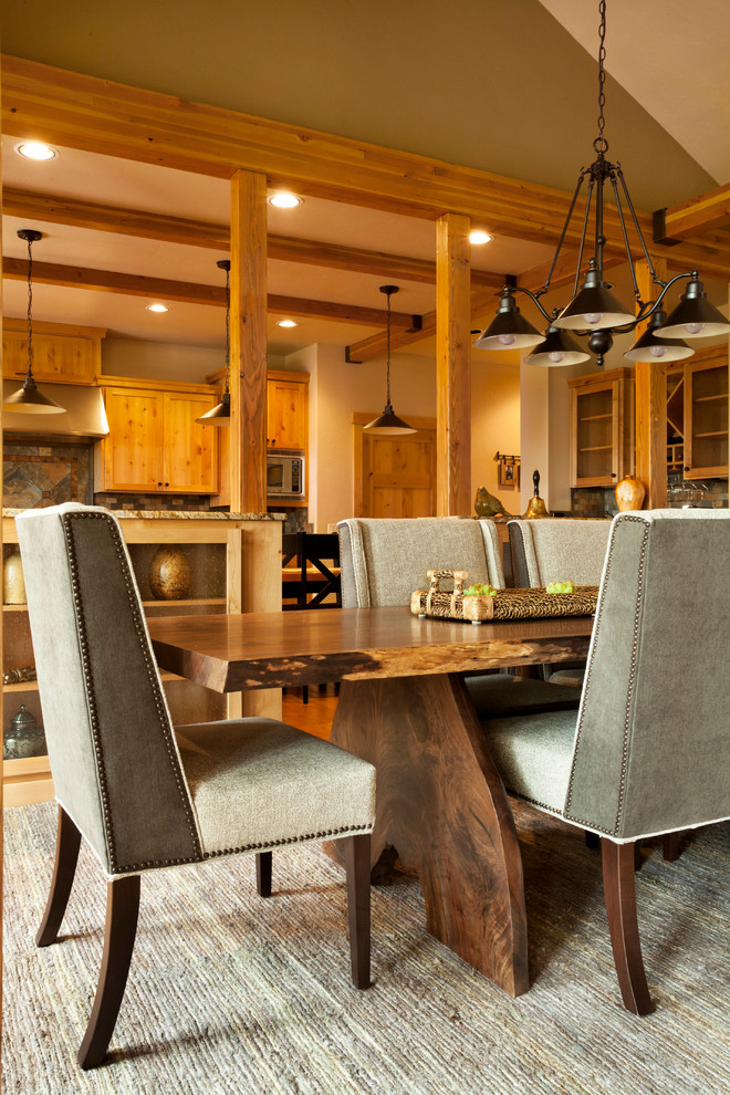 Immagine di una sala da pranzo aperta verso il soggiorno stile rurale con pareti beige e pavimento in legno massello medio