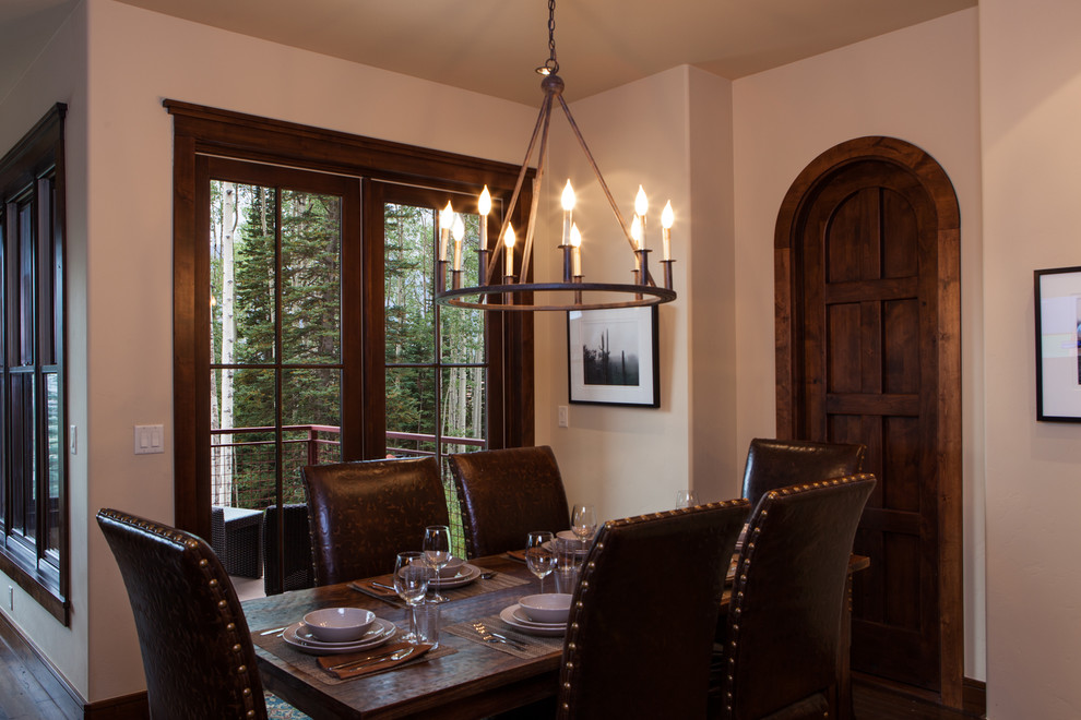 Esempio di una sala da pranzo aperta verso il soggiorno tradizionale di medie dimensioni con pareti beige, parquet scuro e nessun camino