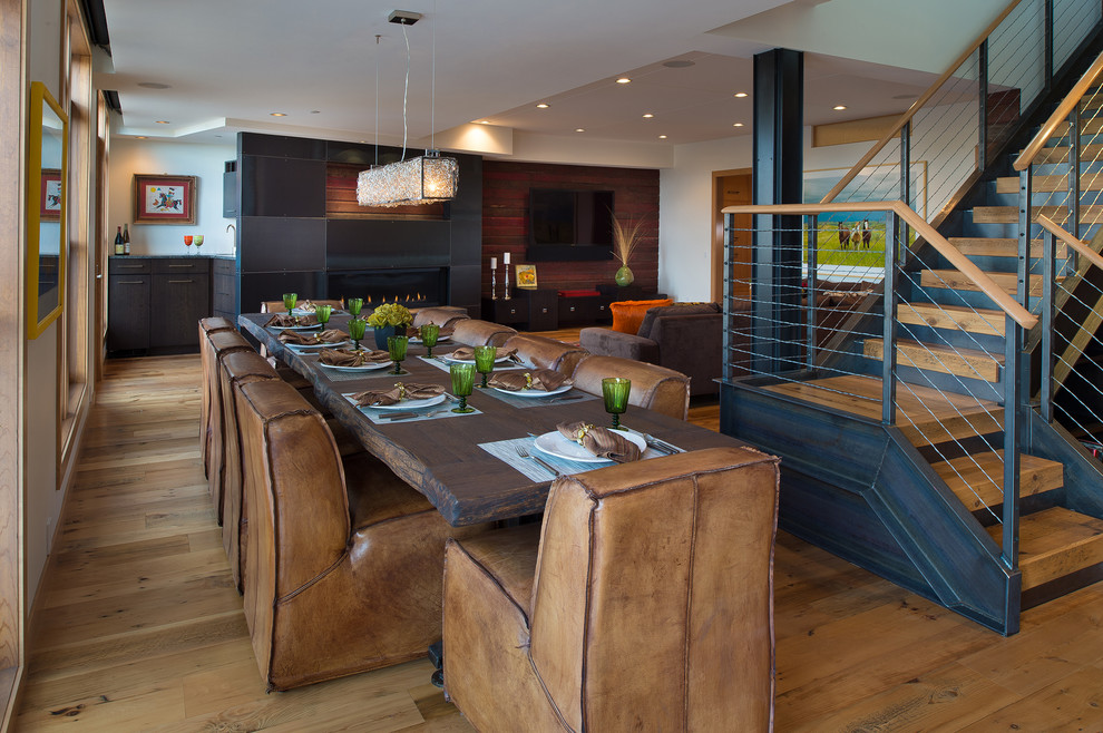 Aménagement d'une salle à manger ouverte sur le salon contemporaine avec un mur blanc et un sol en bois brun.