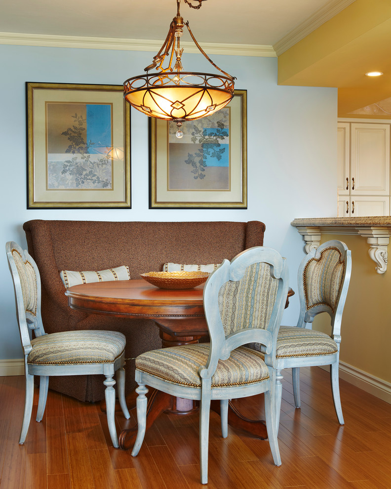 Cette photo montre une salle à manger ouverte sur la cuisine chic avec un mur bleu et un sol en bois brun.