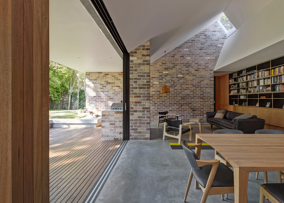 Immagine di una sala da pranzo aperta verso la cucina design di medie dimensioni con pavimento in cemento