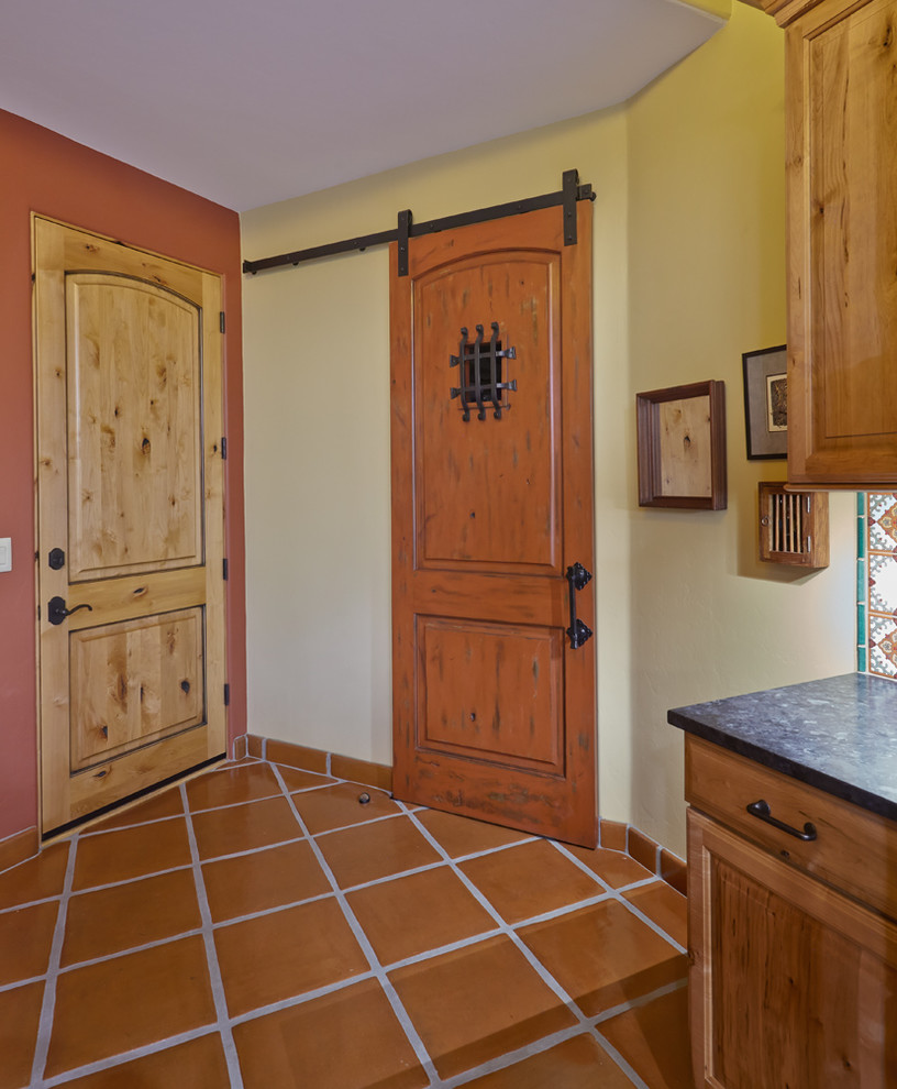 This is an example of an expansive kitchen/dining room in Phoenix with yellow walls and terracotta flooring.
