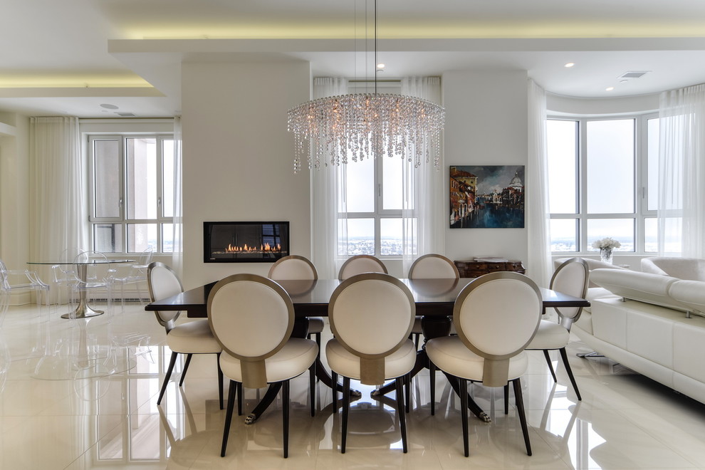 Esempio di una sala da pranzo design di medie dimensioni con pareti bianche, pavimento in marmo, camino classico, cornice del camino in intonaco e pavimento bianco