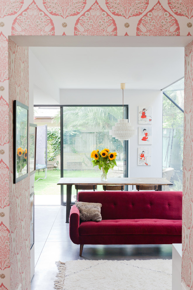 Стильный дизайн: гостиная-столовая среднего размера с розовыми стенами, бетонным полом и серым полом - последний тренд