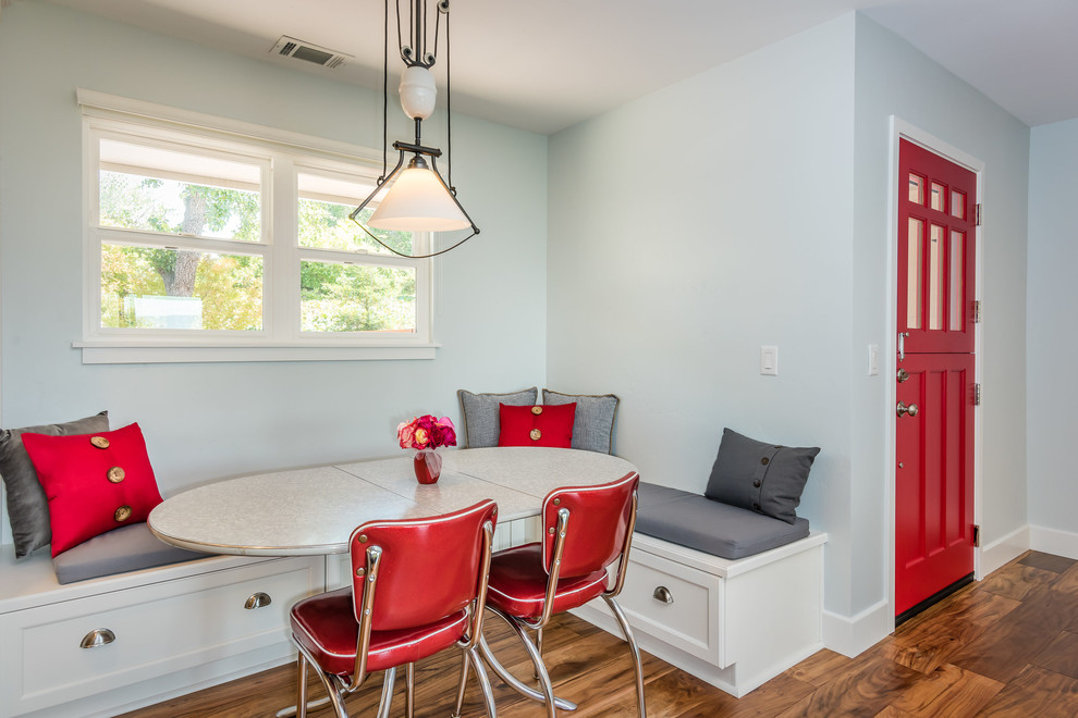 Aménagement d'une salle à manger ouverte sur la cuisine craftsman de taille moyenne avec un mur bleu, un sol en bois brun et un manteau de cheminée en brique.