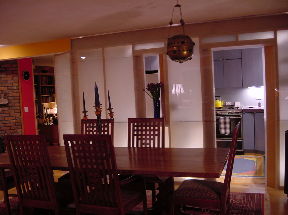 Idee per una piccola sala da pranzo aperta verso la cucina design con pareti marroni, parquet chiaro e nessun camino