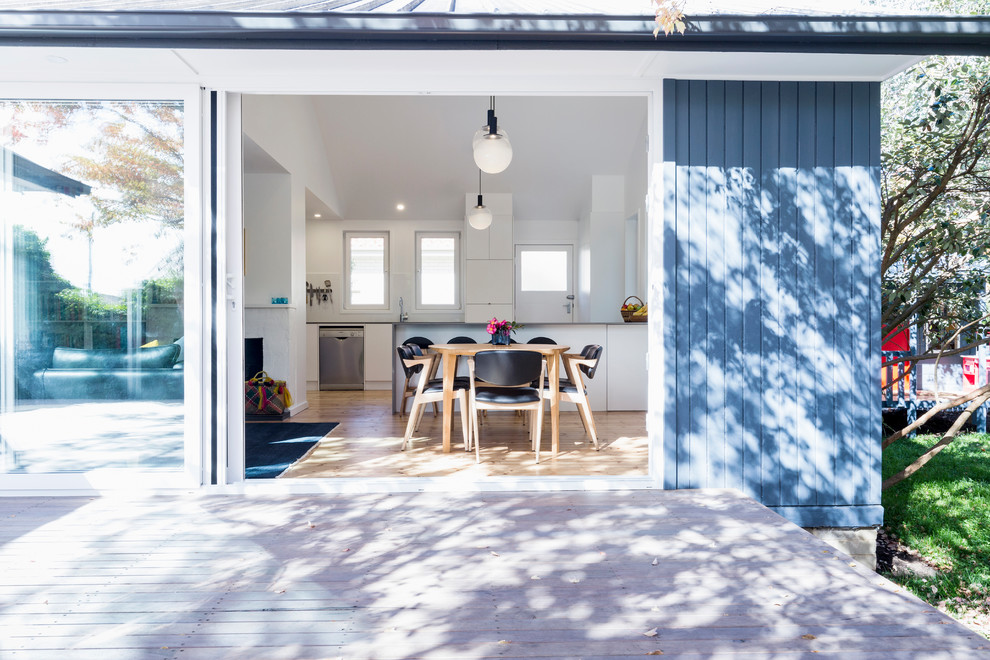 Foto de comedor contemporáneo pequeño abierto con paredes blancas, suelo de madera en tonos medios y suelo marrón