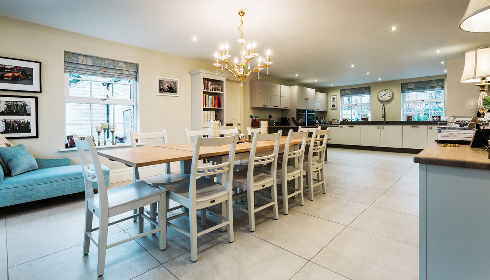 Esempio di una grande sala da pranzo aperta verso la cucina country con pareti beige, pavimento con piastrelle in ceramica e pavimento beige