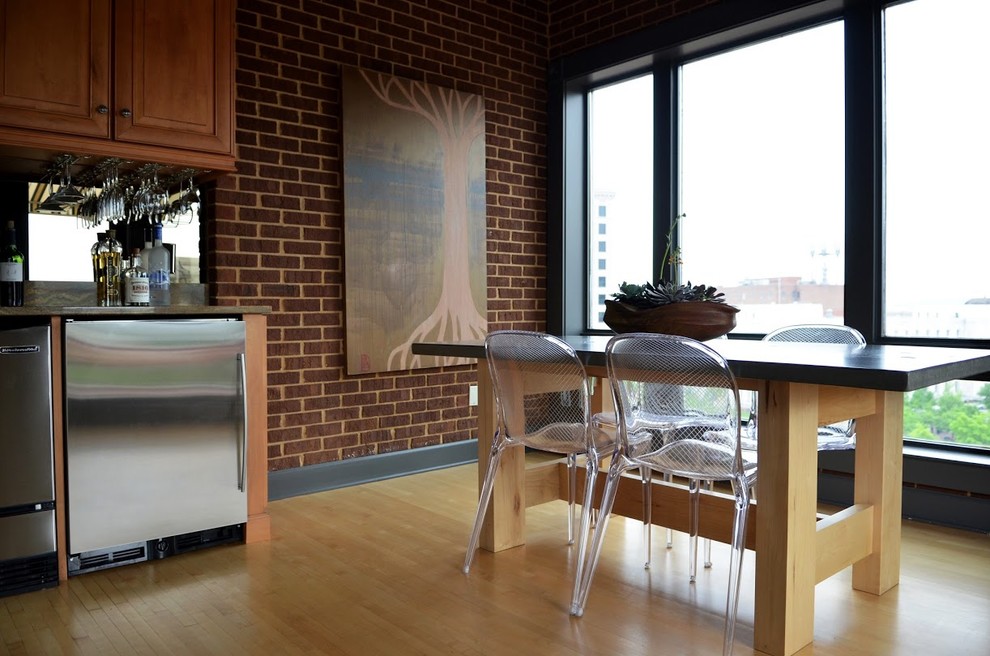 Ispirazione per una sala da pranzo aperta verso la cucina minimal con pavimento in legno massello medio