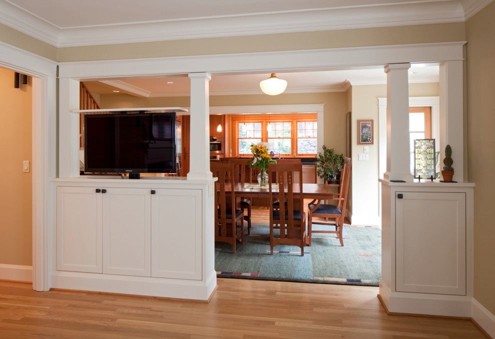 Immagine di una grande sala da pranzo aperta verso la cucina american style con pareti beige, pavimento in legno massello medio e nessun camino