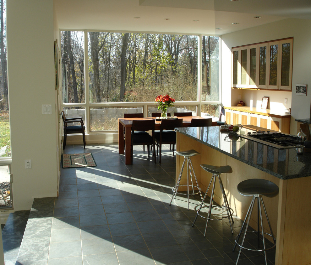 Идея дизайна: кухня-столовая среднего размера в стиле модернизм с серыми стенами, полом из сланца, стандартным камином и фасадом камина из камня