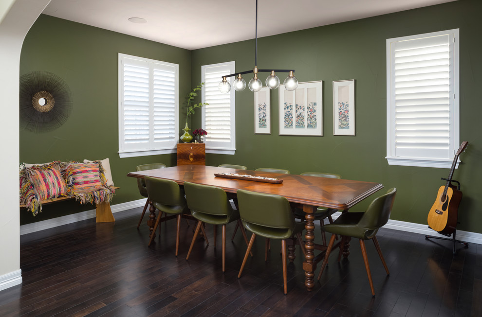 Immagine di una sala da pranzo aperta verso il soggiorno minimalista di medie dimensioni con pareti verdi, parquet scuro, nessun camino e pavimento marrone