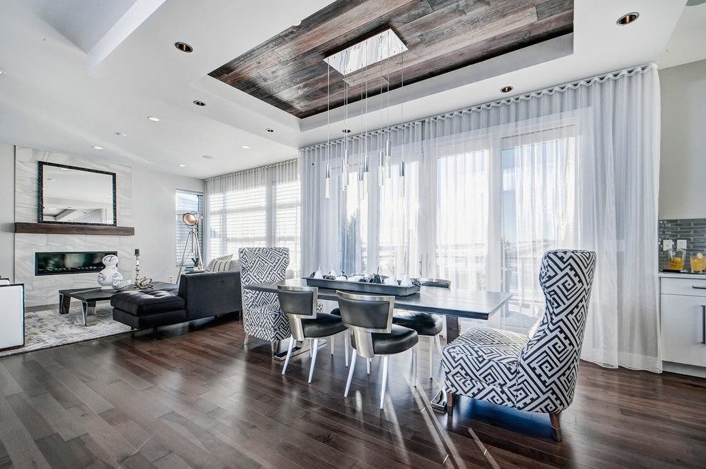Offenes, Mittelgroßes Modernes Esszimmer mit grauer Wandfarbe, braunem Holzboden, gefliester Kaminumrandung, Gaskamin und grauem Boden in Montreal