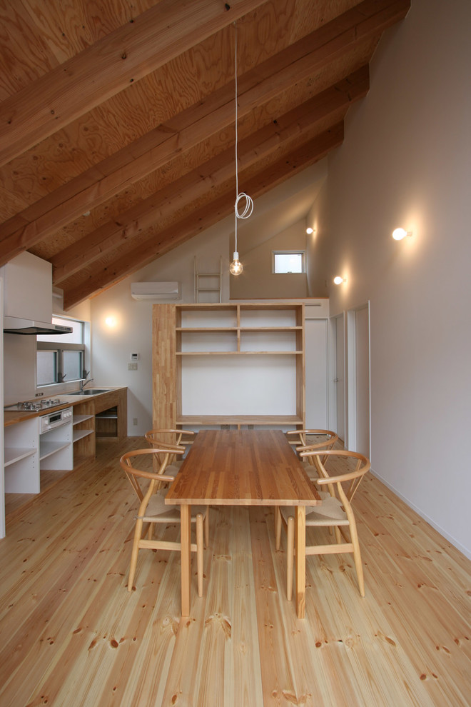 Стильный дизайн: кухня-столовая в современном стиле с белыми стенами и светлым паркетным полом - последний тренд