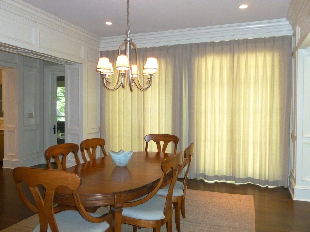 Immagine di una grande sala da pranzo aperta verso la cucina classica con pareti bianche e parquet scuro