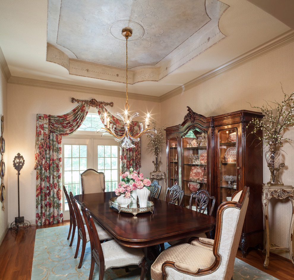 Example of a large classic medium tone wood floor enclosed dining room design in Other with white walls