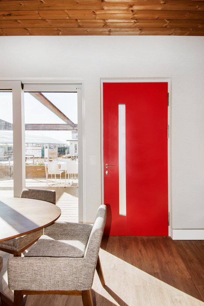 Foto di una piccola sala da pranzo aperta verso il soggiorno moderna con pareti bianche e pavimento in legno massello medio
