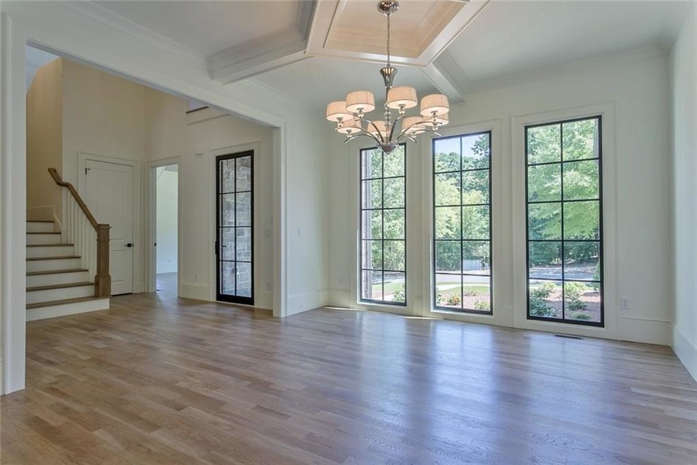 Large transitional light wood floor and gray floor enclosed dining room photo in Atlanta with white walls
