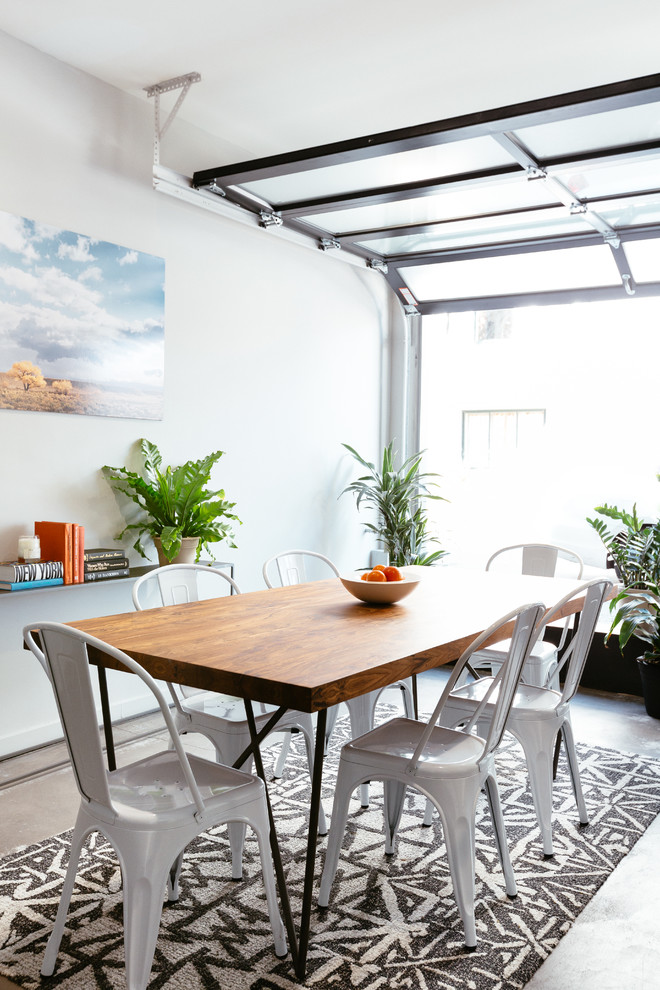 Esempio di una sala da pranzo aperta verso la cucina minimal di medie dimensioni con pareti grigie e pavimento in cemento