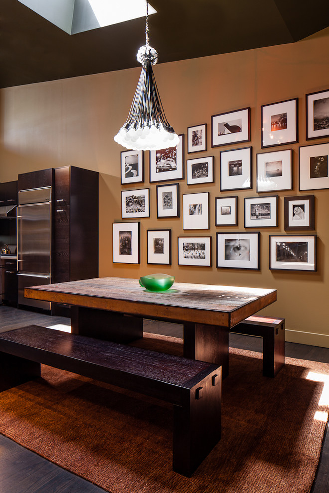 На фото: кухня-столовая в современном стиле с коричневыми стенами и темным паркетным полом