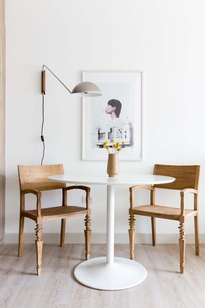 Inspiration for a small scandi dining room in San Francisco with white walls, light hardwood flooring, no fireplace and feature lighting.