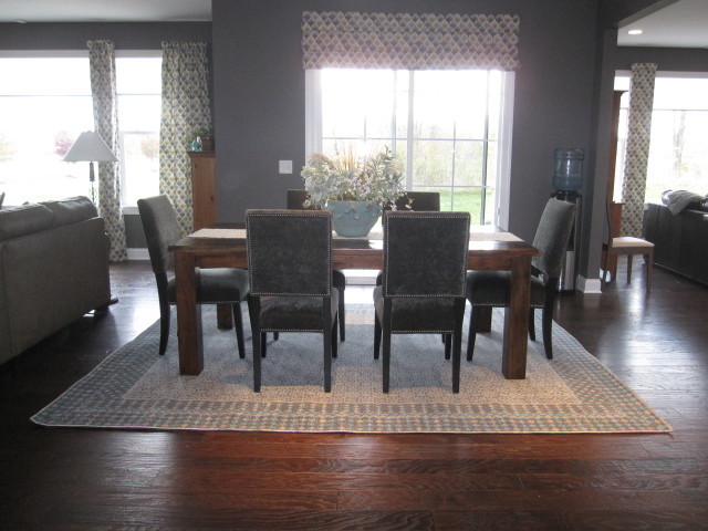 Immagine di una sala da pranzo aperta verso la cucina rustica di medie dimensioni con pareti grigie, parquet scuro e pavimento marrone