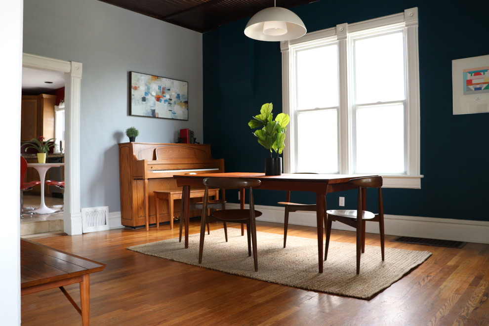 На фото: отдельная столовая среднего размера в стиле ретро с синими стенами, светлым паркетным полом и коричневым полом без камина