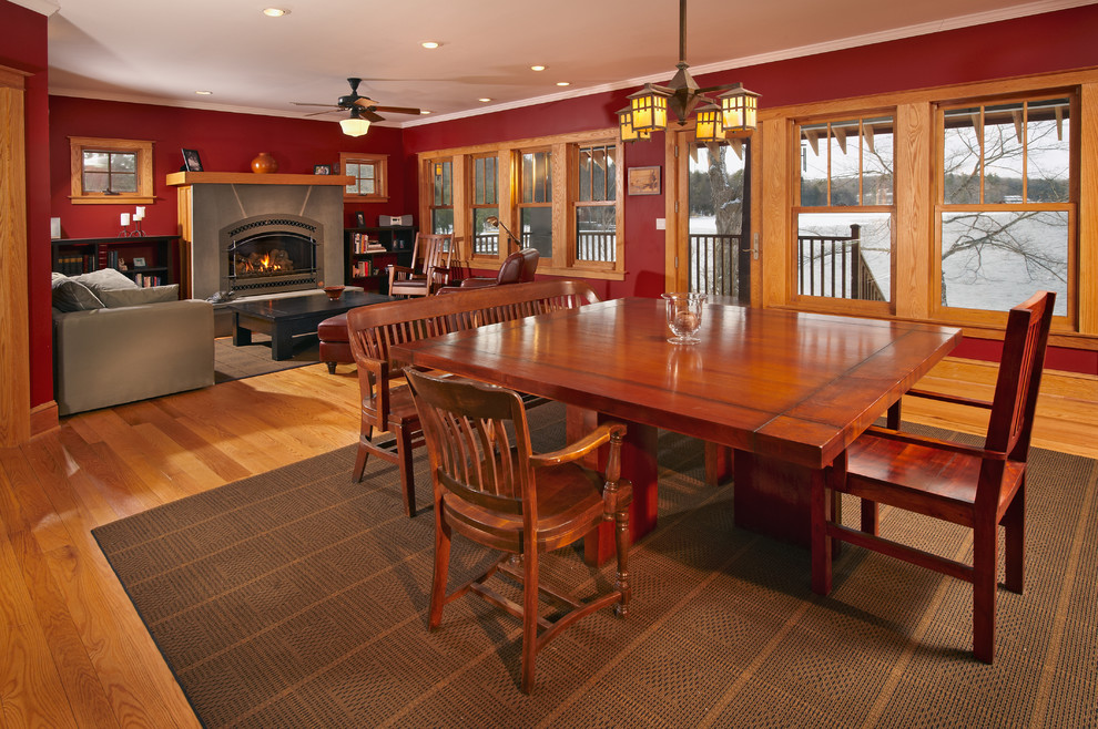 Immagine di una sala da pranzo aperta verso il soggiorno tradizionale con pareti rosse