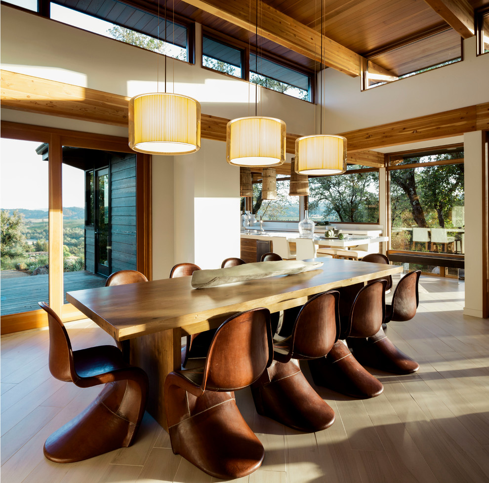 Immagine di una sala da pranzo aperta verso il soggiorno contemporanea con pareti beige, parquet chiaro e nessun camino