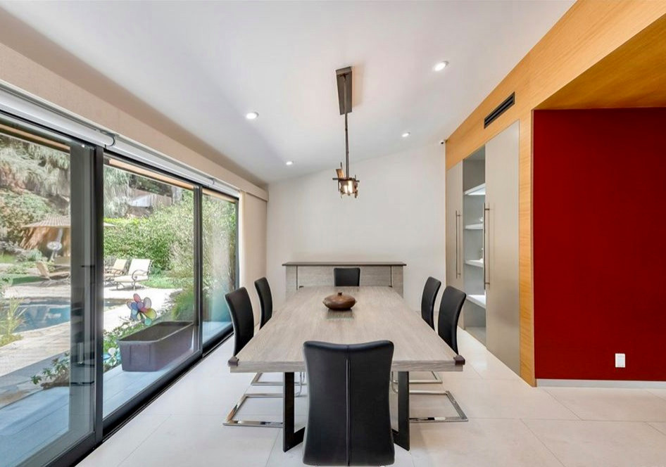 Photo of a medium sized contemporary kitchen/dining room in Los Angeles with white walls, limestone flooring, white floors and a vaulted ceiling.