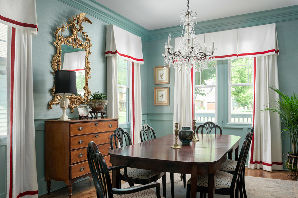 Exemple d'une salle à manger ouverte sur la cuisine chic de taille moyenne avec un mur bleu et un sol en bois brun.