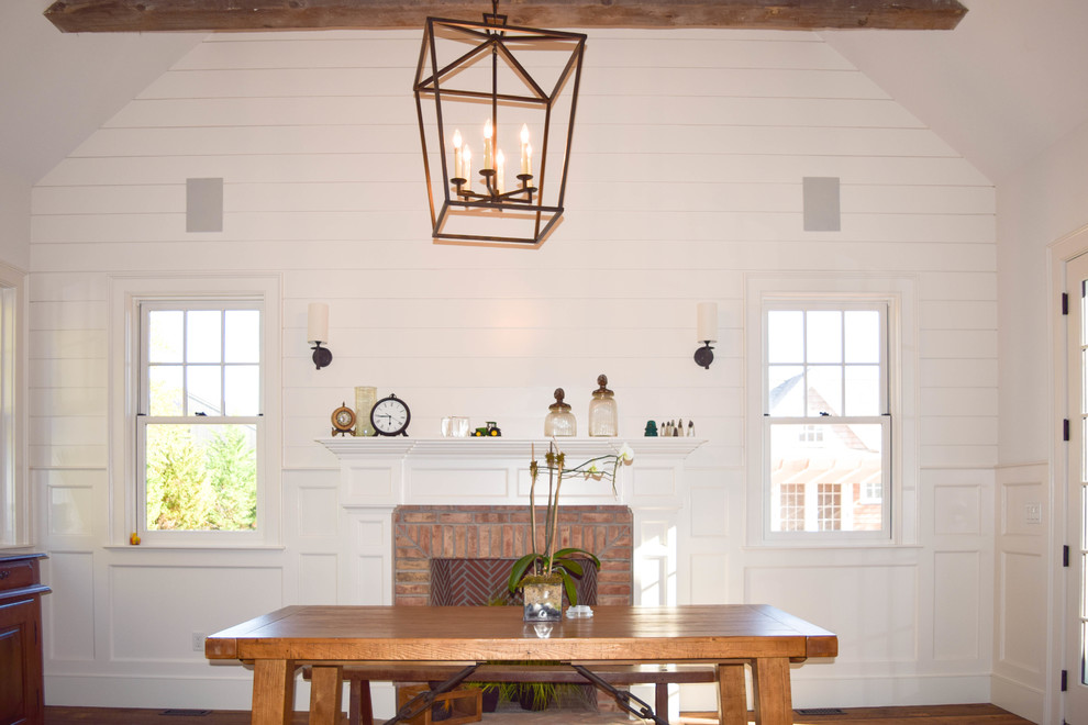 Diseño de comedor de cocina de estilo de casa de campo grande con paredes blancas, suelo de madera en tonos medios, todas las chimeneas y marco de chimenea de ladrillo
