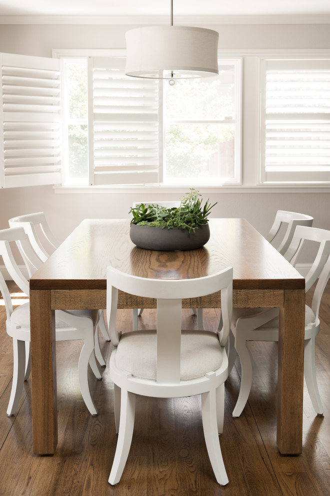 Exemple d'une salle à manger ouverte sur la cuisine chic de taille moyenne avec un mur gris et un sol en bois brun.