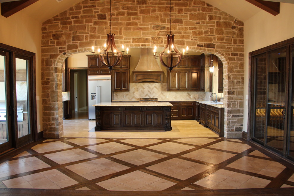 This is an example of a mediterranean kitchen/dining room in Dallas with beige walls and travertine flooring.