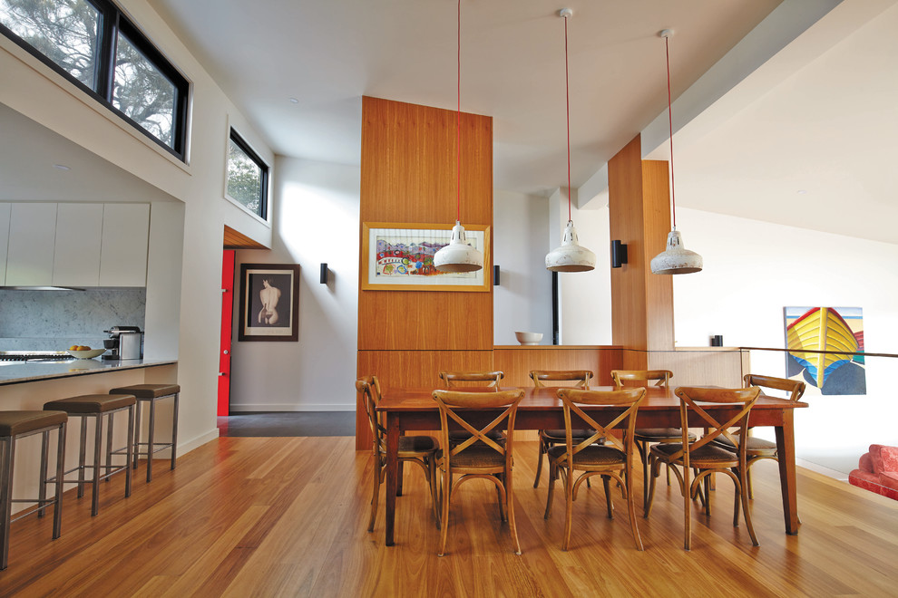 Стильный дизайн: кухня-столовая в современном стиле с белыми стенами, паркетным полом среднего тона и коричневым полом - последний тренд