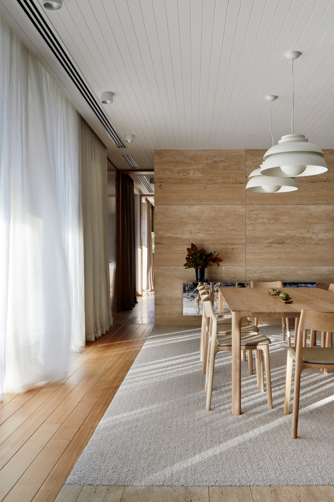 Идея дизайна: большая гостиная-столовая в морском стиле с бежевыми стенами, полом из травертина, коричневым полом, потолком из вагонки и панелями на части стены