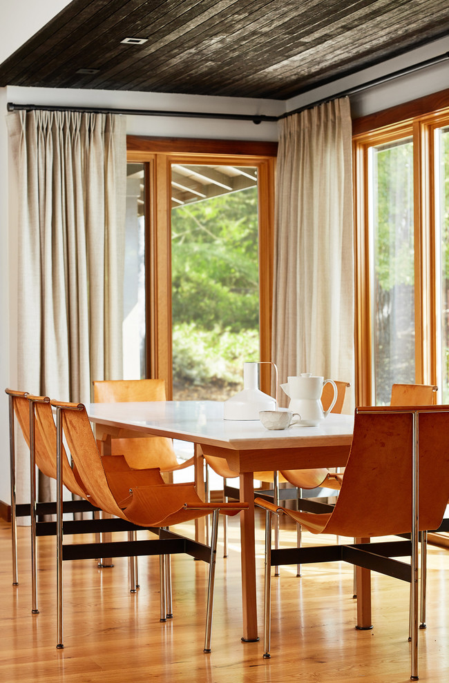 Ispirazione per una sala da pranzo minimal con pareti bianche, pavimento in legno massello medio e pavimento marrone
