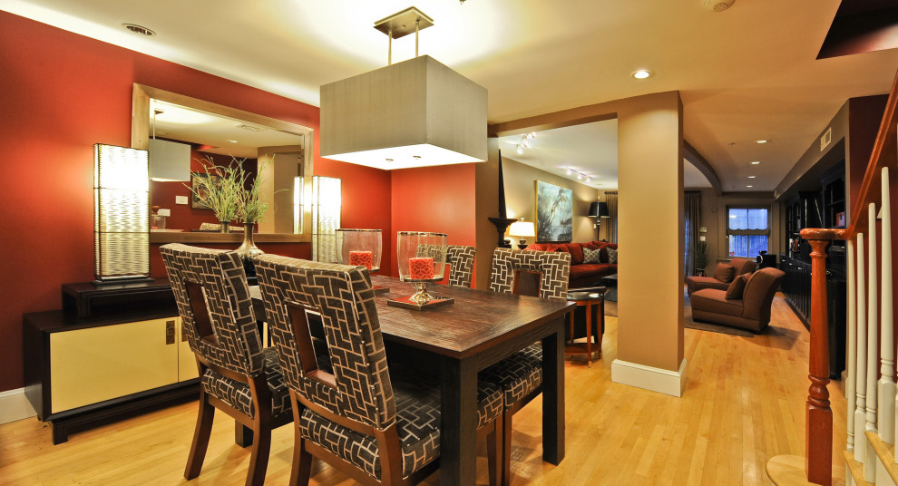 Immagine di una sala da pranzo minimal di medie dimensioni con pareti rosse, parquet chiaro e pavimento giallo