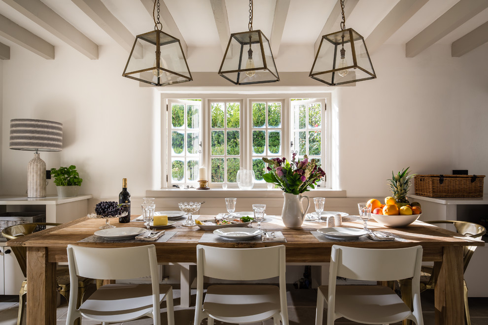 Inspiration pour une salle à manger ouverte sur la cuisine rustique avec un mur blanc, parquet clair et éclairage.