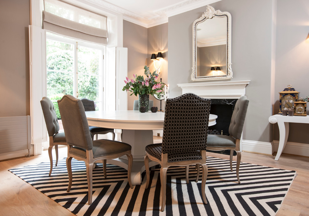 Inspiration for a contemporary dining room in London with grey walls, carpet and a stone fireplace surround.
