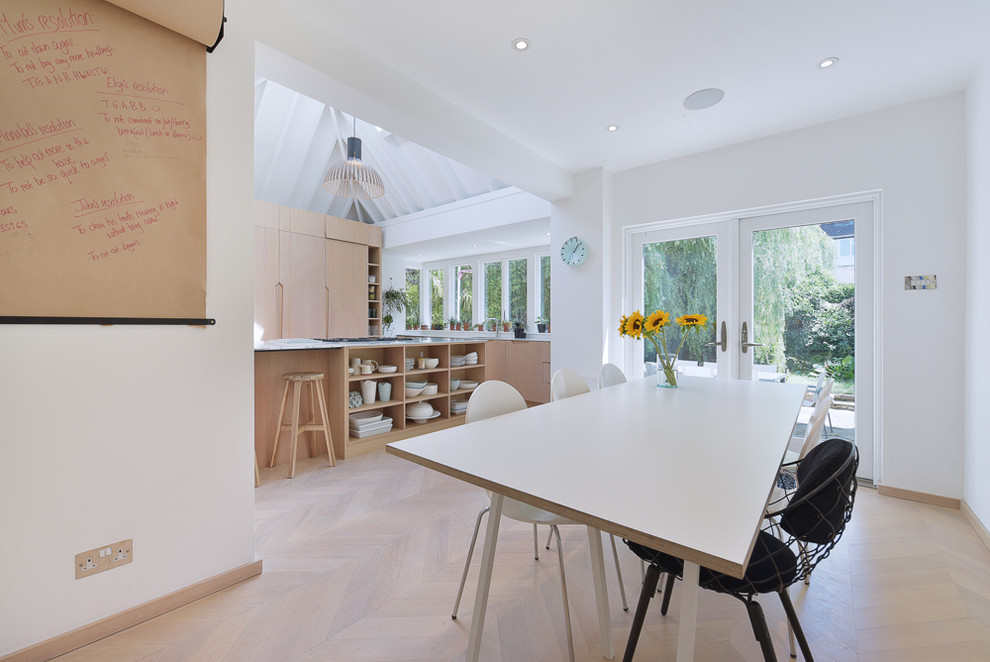 Kitchen/dining room combo - contemporary light wood floor and beige floor kitchen/dining room combo idea in London with white walls
