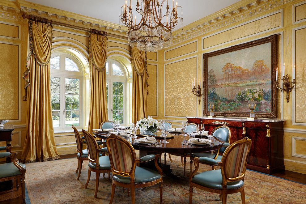 Immagine di una sala da pranzo mediterranea chiusa con pareti gialle, parquet scuro e pavimento marrone
