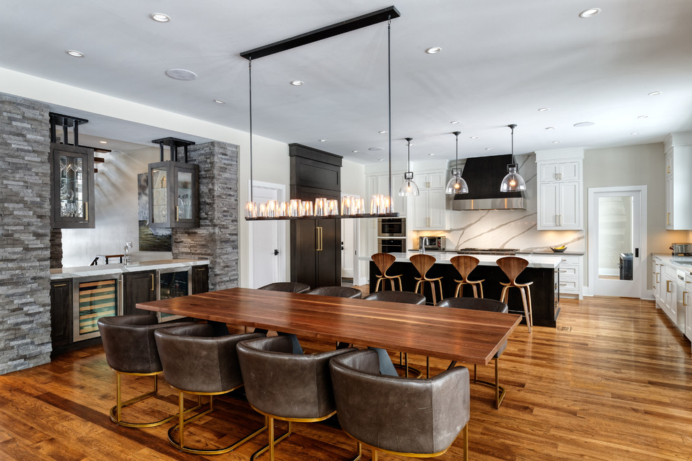 Cette photo montre une salle à manger ouverte sur la cuisine tendance avec un sol en bois brun et un sol marron.