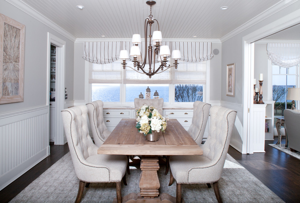 Photo of a beach style enclosed dining room in New York with grey walls, dark hardwood flooring, no fireplace and feature lighting.