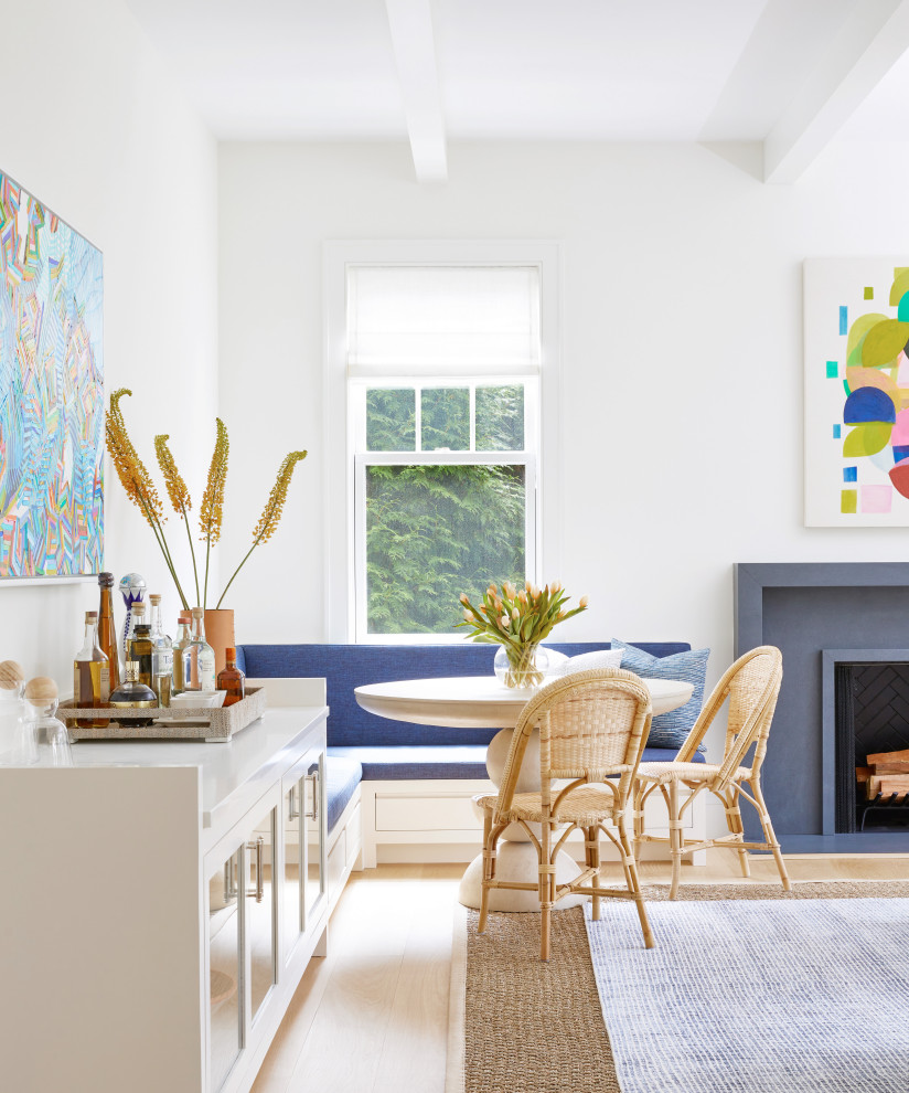 Imagen de comedor costero de tamaño medio con paredes blancas, suelo de madera clara, con oficina y suelo beige