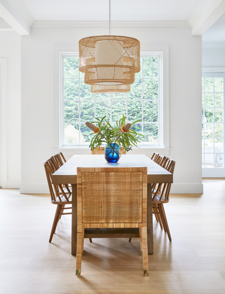 Example of a mid-sized beach style light wood floor and brown floor kitchen/dining room combo design in New York with white walls